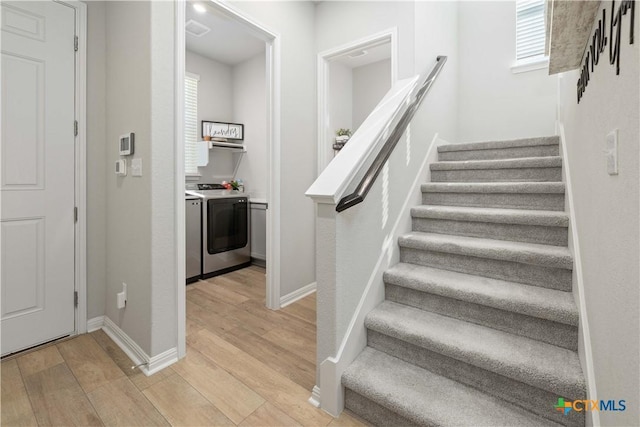 staircase featuring independent washer and dryer and wood-type flooring