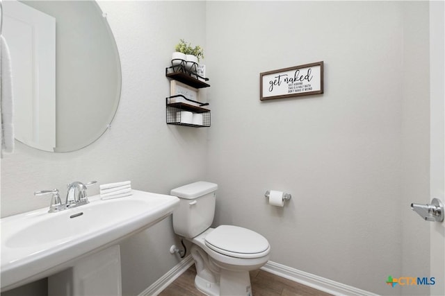 bathroom featuring wood-type flooring, toilet, and sink