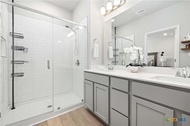 bathroom featuring vanity, a shower with shower door, and hardwood / wood-style floors