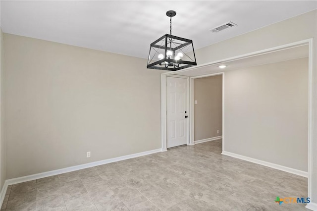 unfurnished room featuring a chandelier