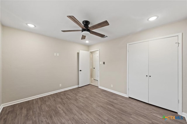 unfurnished bedroom featuring ceiling fan, wood-type flooring, and a closet