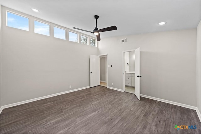 unfurnished bedroom featuring dark wood-type flooring, ceiling fan, and ensuite bath