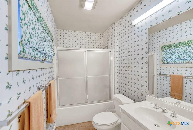 full bathroom featuring vanity, shower / bath combination with glass door, and toilet