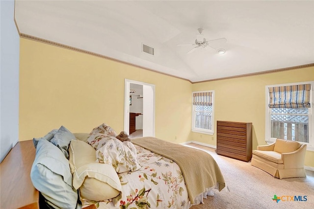 carpeted bedroom with lofted ceiling, crown molding, and ceiling fan