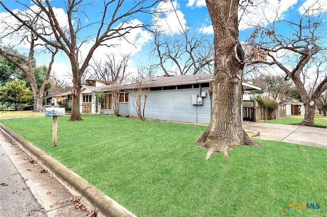 ranch-style home featuring a front lawn and a carport