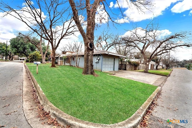 ranch-style house featuring a garage and a front lawn