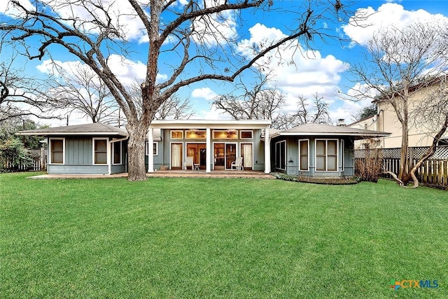 rear view of house featuring a yard