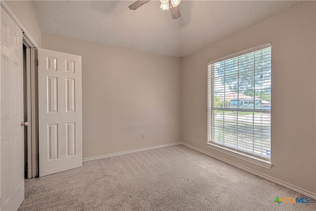 607 Moccasin Dr, Harker Heights, TX 76548 - unfurnished bedroom with multiple windows, carpet flooring, a textured ceiling, and a ceiling fan