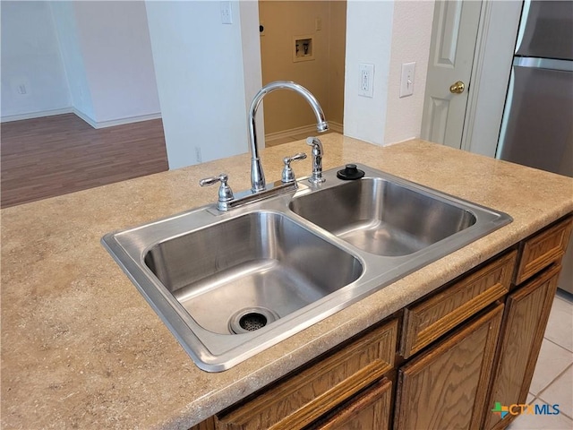 607 Moccasin Dr, Harker Heights, TX 76548 - kitchen view of light countertops, refrigerator, and brown cabinetry