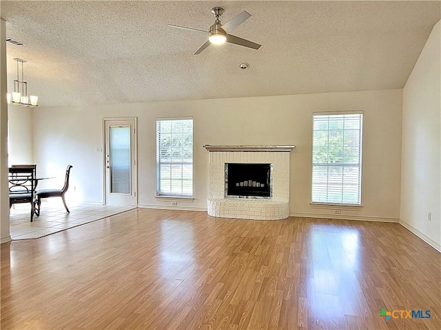 607 Moccasin Dr, Harker Heights, TX 76548 - unfurnished living room featuring a textured ceiling, healthy amount of natural light, light wood-style floors, a ceiling fan, and a chandelier