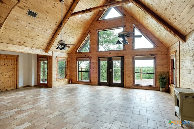 unfurnished living room featuring ceiling fan, wooden walls, wooden ceiling, and beamed ceiling