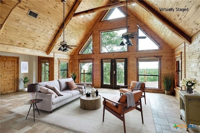 living room with ceiling fan, wooden ceiling, beam ceiling, and wood walls