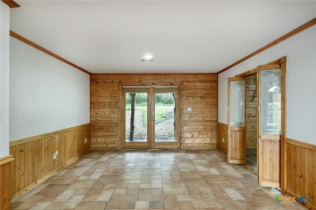 doorway to outside featuring crown molding and wood walls