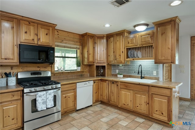 kitchen with sink, gas range, decorative backsplash, and dishwasher