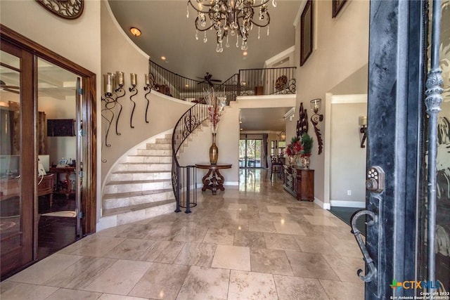 entrance foyer with a chandelier, a high ceiling, baseboards, and stairs