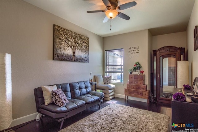 living area featuring baseboards, wood finished floors, and ceiling fan