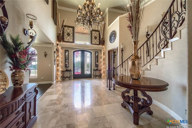 foyer entrance featuring crown molding, stairs, an inviting chandelier, baseboards, and a high ceiling