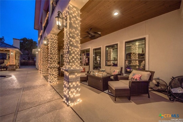 view of patio featuring ceiling fan and an outdoor living space with a fire pit