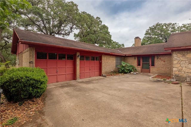 408 Royal Oak Dr, Victoria, TX 77905 - view of front of home featuring a garage, driveway, a chimney, brick siding, and roof with shingles