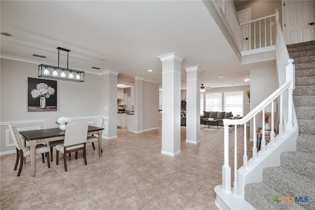 dining area featuring ornate columns, ceiling fan, and crown molding