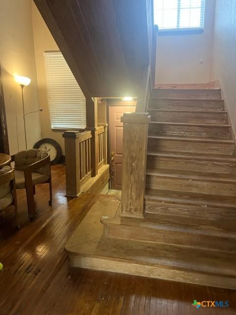 stairs featuring hardwood / wood-style floors