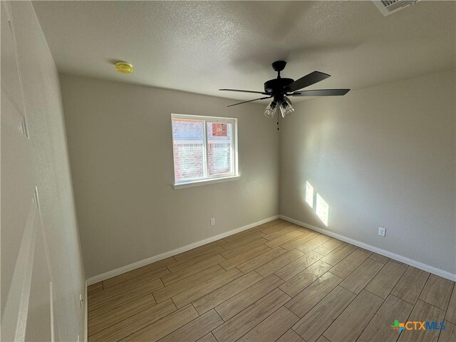 2516 Cowgirl Trl, Belton, TX 76513 - spare room with wood finished floors, a ceiling fan, and a textured ceiling