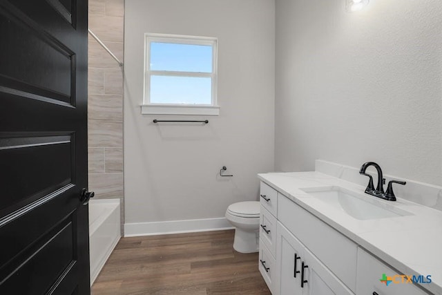 full bathroom with shower / tub combination, vanity, wood-type flooring, and toilet