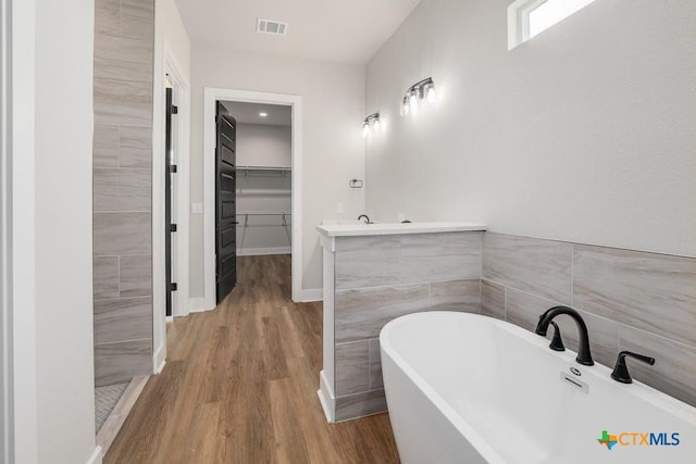 bathroom featuring a tub to relax in, vanity, and hardwood / wood-style flooring