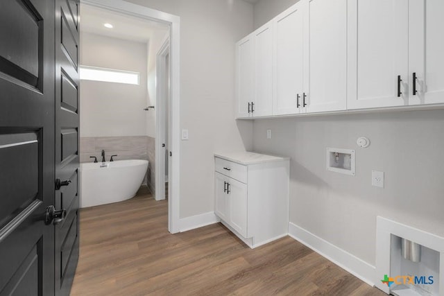 laundry area with cabinets, washer hookup, and dark hardwood / wood-style floors