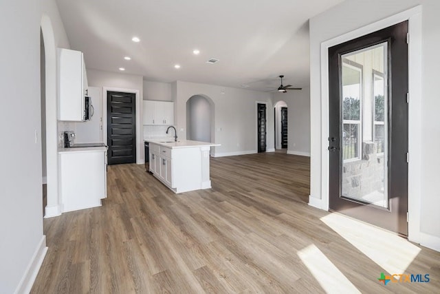 kitchen featuring white cabinets, a center island with sink, ceiling fan, and sink