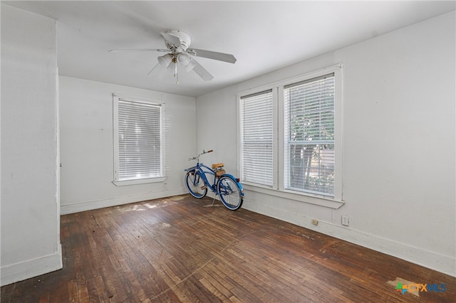 empty room with dark wood-type flooring and ceiling fan