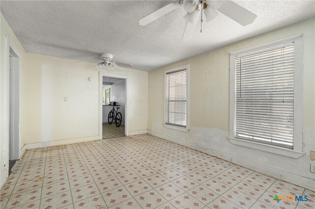 unfurnished room featuring a textured ceiling and ceiling fan