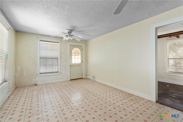 foyer entrance featuring ceiling fan and a textured ceiling