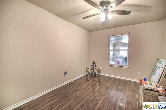 empty room with dark hardwood / wood-style flooring and ceiling fan