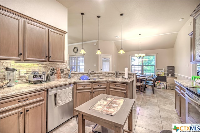 kitchen with sink, appliances with stainless steel finishes, backsplash, decorative light fixtures, and vaulted ceiling