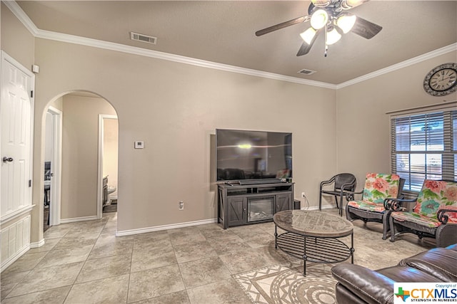 living room featuring ornamental molding, ceiling fan, and a fireplace