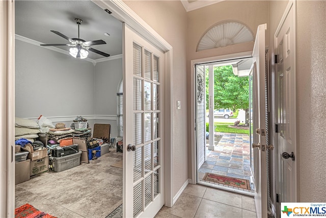 tiled foyer entrance featuring ceiling fan, french doors, and ornamental molding