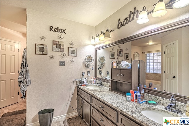 bathroom featuring tile patterned flooring, vanity, and a textured ceiling