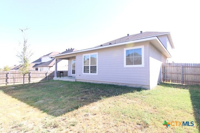 rear view of house featuring a lawn