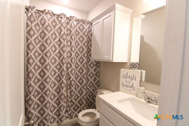 bathroom featuring curtained shower, vanity, and toilet