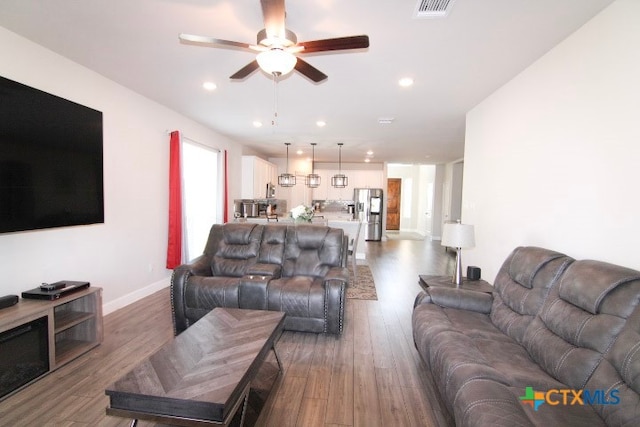 living room with wood-type flooring and ceiling fan