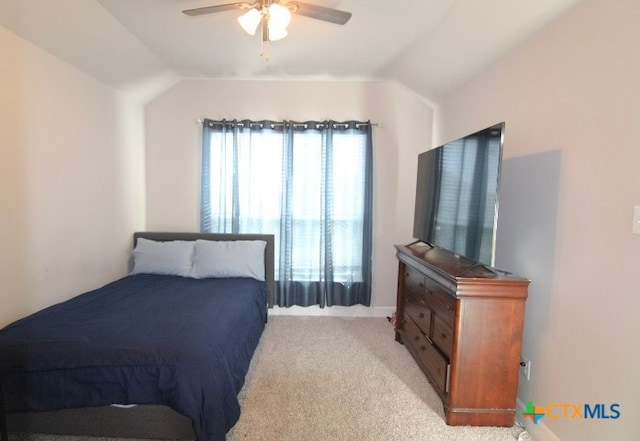 bedroom with ceiling fan, vaulted ceiling, and light colored carpet