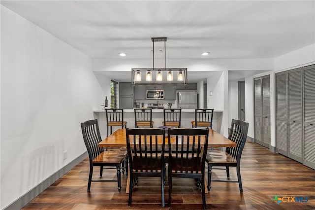 dining space with baseboards, dark wood finished floors, and recessed lighting