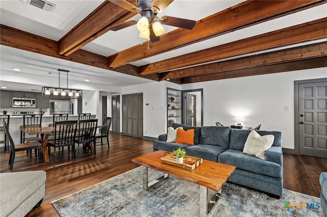 living area featuring ceiling fan, visible vents, baseboards, dark wood-style floors, and beamed ceiling