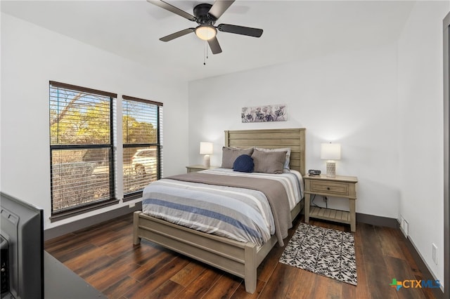 bedroom featuring ceiling fan, dark wood-style flooring, visible vents, and baseboards