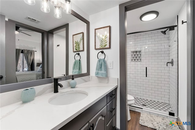 ensuite bathroom with a stall shower, visible vents, ensuite bath, wood finished floors, and vanity