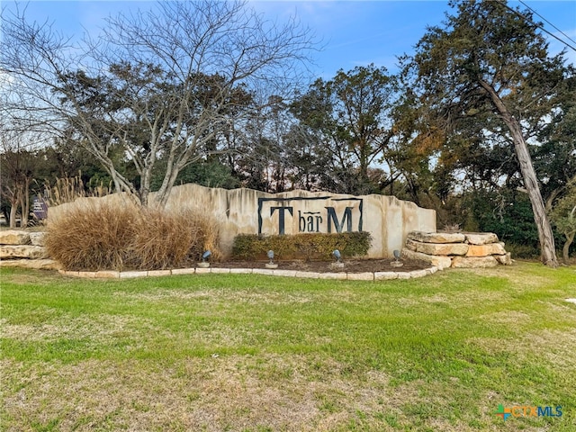 community / neighborhood sign featuring a yard