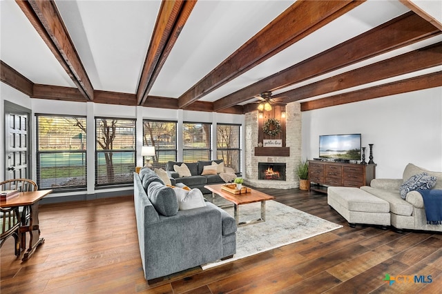 living area featuring dark wood finished floors, a wealth of natural light, and a stone fireplace