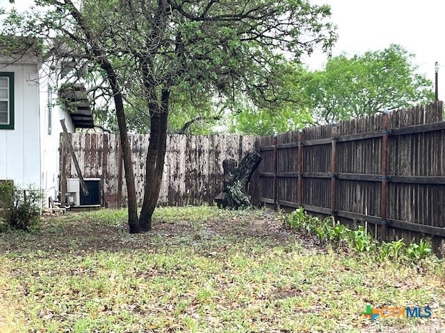view of yard with cooling unit and a fenced backyard