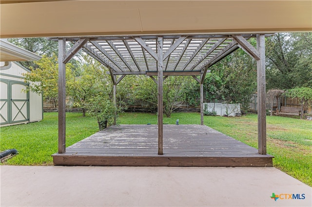 deck featuring a pergola, a storage unit, and a yard